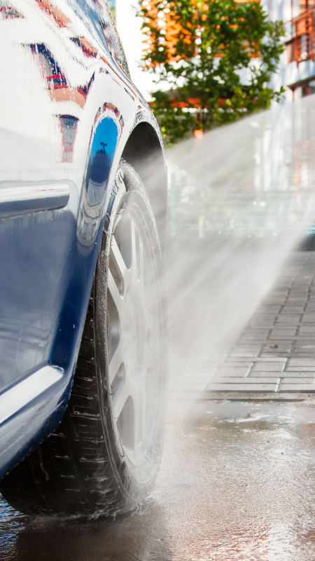 a car with water spraying on the tire